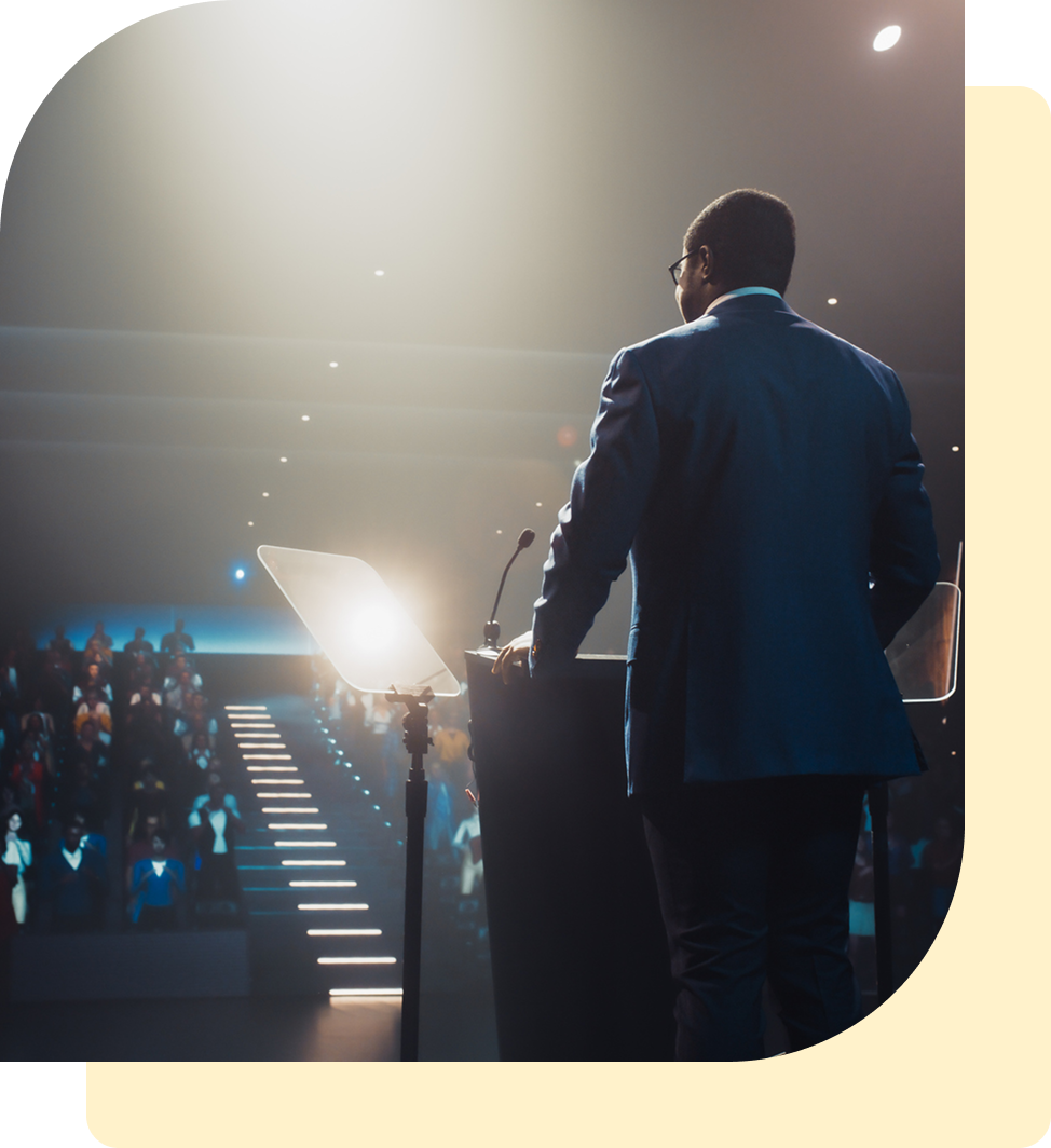 Speaker addressing audience in auditorium